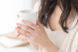 © lielos - 朝、温かい飲み物を飲む女性