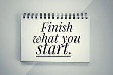 Motivational Words - Finish What You Start. Text Message On A Spiral Notebook. Inspirational Quote Concept On Paper Book.