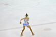 Girl figure skater rolls on a skating rink with artificial ice 