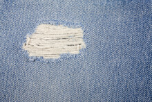 Blue torn denim jeans texture.