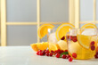 Delicious cocktails with orange, cranberries and ice balls on light grey marble table. Space for text