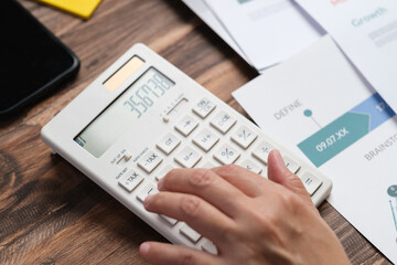 Poster - close up hand using calculator calculate tax and budget of project at home