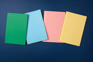 Poster - top view pastel notebook with pencil and stationery on navy blue table background