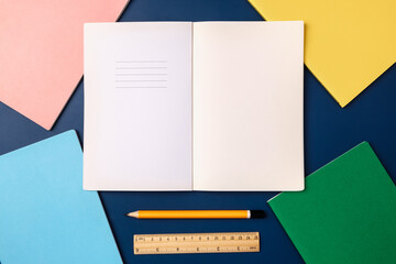 Poster - top view pastel notebook with pencil and stationery on navy blue table background