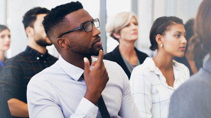 Poster - Hmm, so much to think about. Cropped shot of a handsome young businessman sitting with his colleagues while in the office during the day.