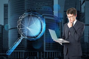 Poster - Attractive young european businessman using laptop with abstract polygonal magnifying glass on blurry city background. Technology, information, search and business network concept. Double exposure.
