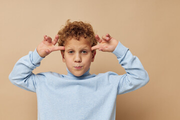 Wall Mural - Cute little boy in a blue sweater posing fun childhood unaltered