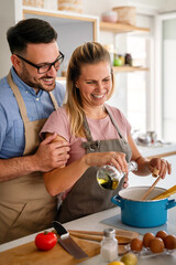 Wall Mural - Attractive couple is cooking together organic healthy food in kitchen.