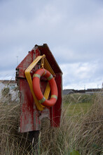 Life Buoy On The Beach With Damaged Container