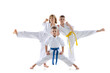 Three sportive kids, little boys, taekwondo or karate athletes in doboks posing isolated on white background. Concept of sport, martial arts
