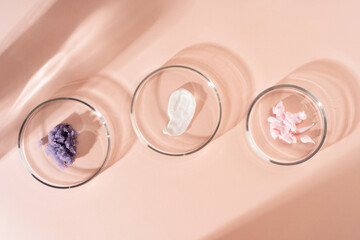 Wall Mural - Cosmetic products, scrub, face serum and gel in many petri dishes on a pastel beige background. Cosmetics laboratory research concept.