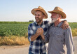 © Budimir Jevtic - Two farmers shaking hands and hugging in field
