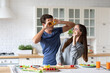 © BestForYou - Positive young couple in love having fun while cooking in kitchen at home, making eyeglasses from bell pepper slices. Enjoying healthy preparing food
