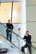 © LIGHTFIELD STUDIOS - wealthy businesswoman near private bodyguards on hotel escalator.
