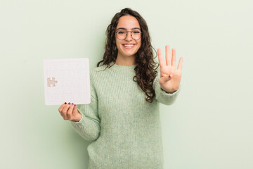 Wall Mural - young pretty hispanic woman smiling and looking friendly, showing number four. puzzle concept