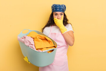 Wall Mural - young pretty hispanic woman covering mouth with hands with a shocked. wash and clothes concept