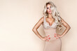 Elegant sexy blonde woman in luxury dress with crystals. Sensual shapely model in mini dress on beige background in studio. Glamour model. luxury fashion. Spring fashion. Vogue.