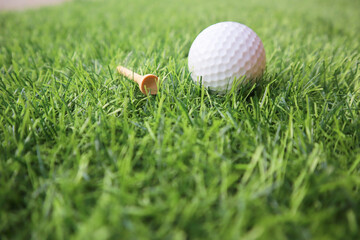 Golf ball close up on green grass on blurred beautiful landscape of golf background.Concept international sport that rely on precision skills for health relaxation..