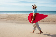 Man With Red Location Pin Walking Along Seashore