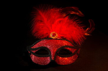 Poster - carnival symbol mask in red gold color with feathers on black background