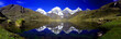 Panorama of snowy mountains reflected in glacial lake at sunrise in the spectacular and remote Cordillera Huayhuash Circuit near Caraz in Peru.