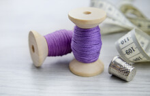 A Spool Of Purple Thread On A Wooden Table. Sewing Accessories. Hobbies And Recreation,sewing Workshop.Trendy Color, Very Peri