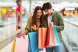 © Prostock-studio - Excited Couple Shopping Holding And Looking At Bags In Hypermarket