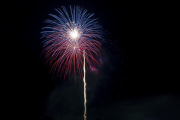 Sticker - Bright festive fireworks against the black sky. Fiery rays of light on a black background.