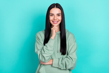 Wall Mural - Photo of cute young black hairstyle lady hand face wear green hoodie isolated on teal color background