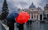 Fototapeta Do przedpokoju - Young couple under umbrellas standing near St Peter's basilica at Vatican. Holidays for couple in Italy
