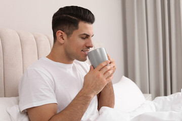 Sticker - Happy man with cup of hot drink in bed at home