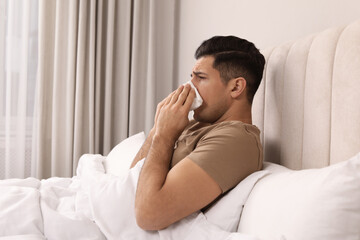 Sticker - Sick man with tissue suffering from cold in bed at home