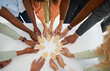 © Studio Romantic - Hands of different business people connecting puzzle pieces as sign of problem solving and teamwork. Top view of multiracial people standing in circle at table with wooden puzzles. Business concept.