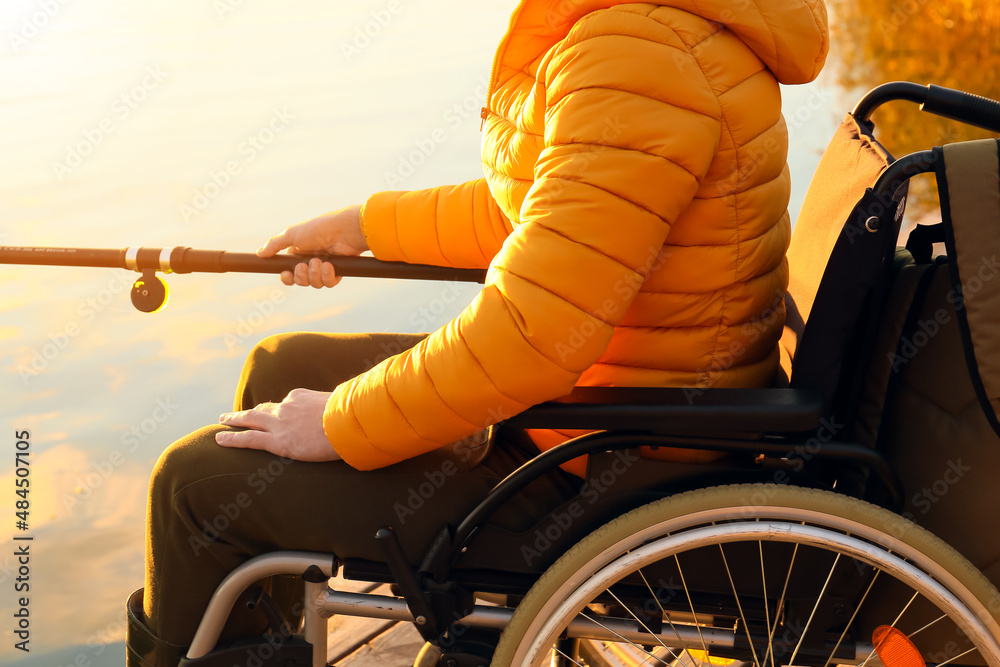Man in wheelchair fishing on river