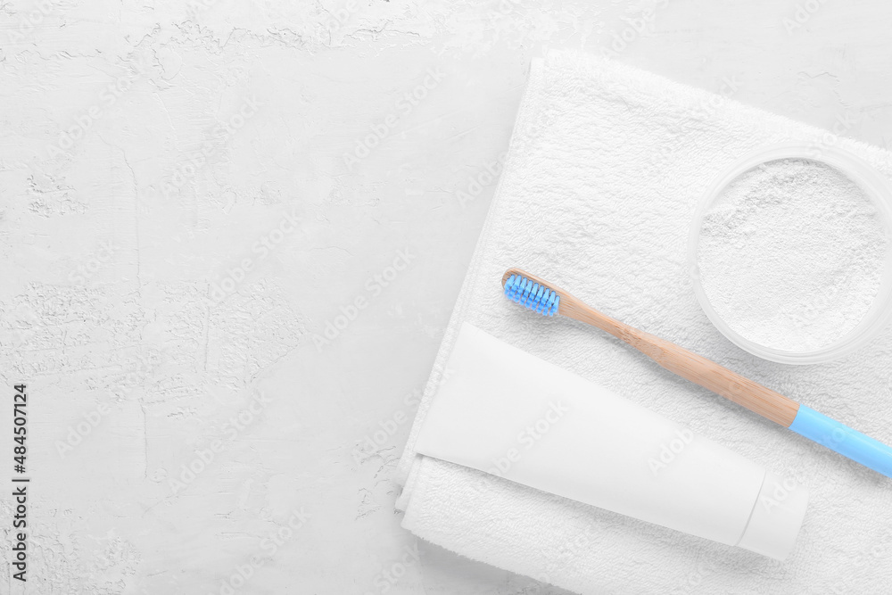 Bamboo tooth brush with paste, powder and towel on white background