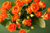 Fototapeta Kwiaty - Bouquet of beautiful orange roses on green background
