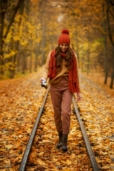 Woman walking with camera in autumn park