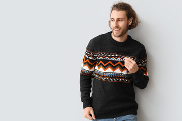 Sticker - Handsome young man in knitted sweater on grey background