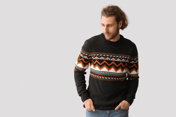 Sticker - Handsome young man in knitted sweater on grey background