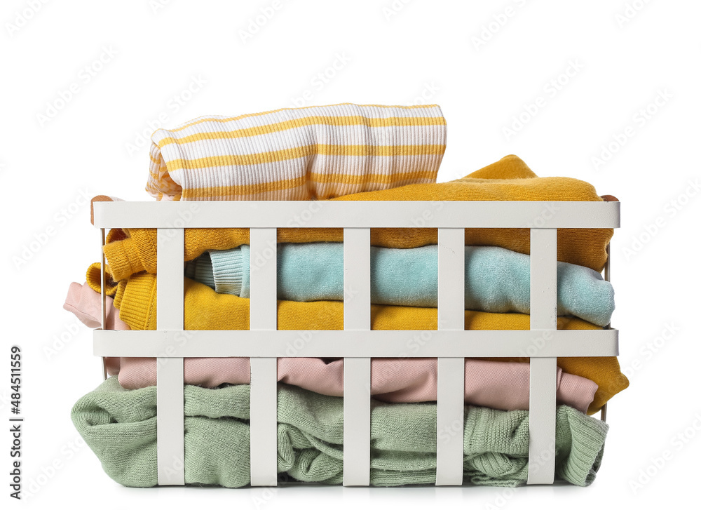 Basket with different folded sweaters on white background