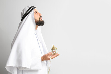 Wall Mural - Muslim man praying on light background