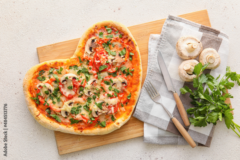 Wooden board with tasty heart-shaped pizza on light background. Valentine's Day celebration