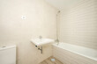 Bathroom with stoic cabinetry and light cream tile and white porcelain fixtures