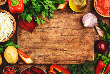 Wall Mural - Various uncooked vegetables, herbs and spices for healthy cooking and cutting board on rustic kitchen wooden table, top view. Preparation vegetarian cabbage, beetroot, tomato soup. Vegan, food