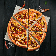 Sticker - American pizza with minced meat on dark wood background. Italian dish - homemade pizza with bolognese sauce, pickled and tomatoes on parchment. Junk food on wooden table. Meat pizza in rustic style.