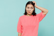 Young mistaken puzzled woman of Asian ethnicity 20s in pink sweater look aside on workspace scratch hold head isolated on pastel plain light blue background studio portrait People lifestyle concept.