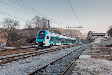 Wall Mural - Modern slovenian double decker commuter train is just leaving the rural station of Podnart. Cold and early afternoon in northern Slovenia.