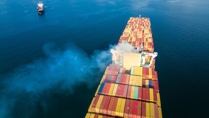 Stern of large cargo ship with Smoke exhaust gas emissions from cargo lagre ship ,Marine diesel enginse exhaust gas from combustion. forward mast