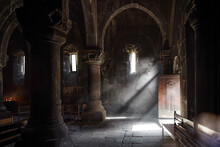 Stone Interior With Arch And Column Of Ancient Armenian Church In The Highlands. Dark Hall And Rays Of Light Full Of Mist From The Small Window.