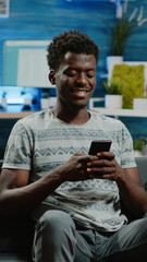 Poster - Adult holding smartphone for text messages on touch screen. Man using phone after remote work, texting on device. Freelancer using gadget for online communication and browsing internet